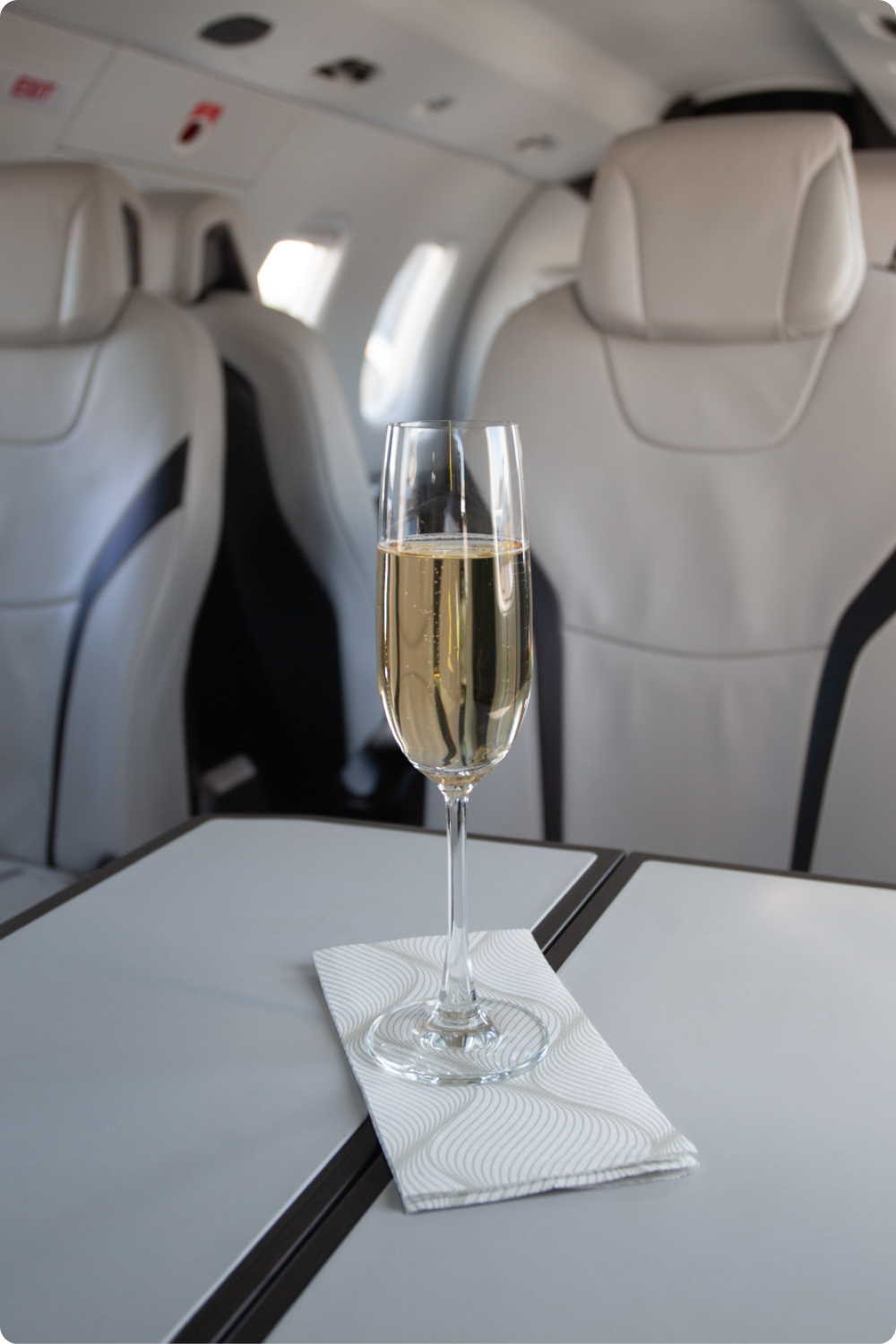 Glass of champagne on a cabin table between leather seats